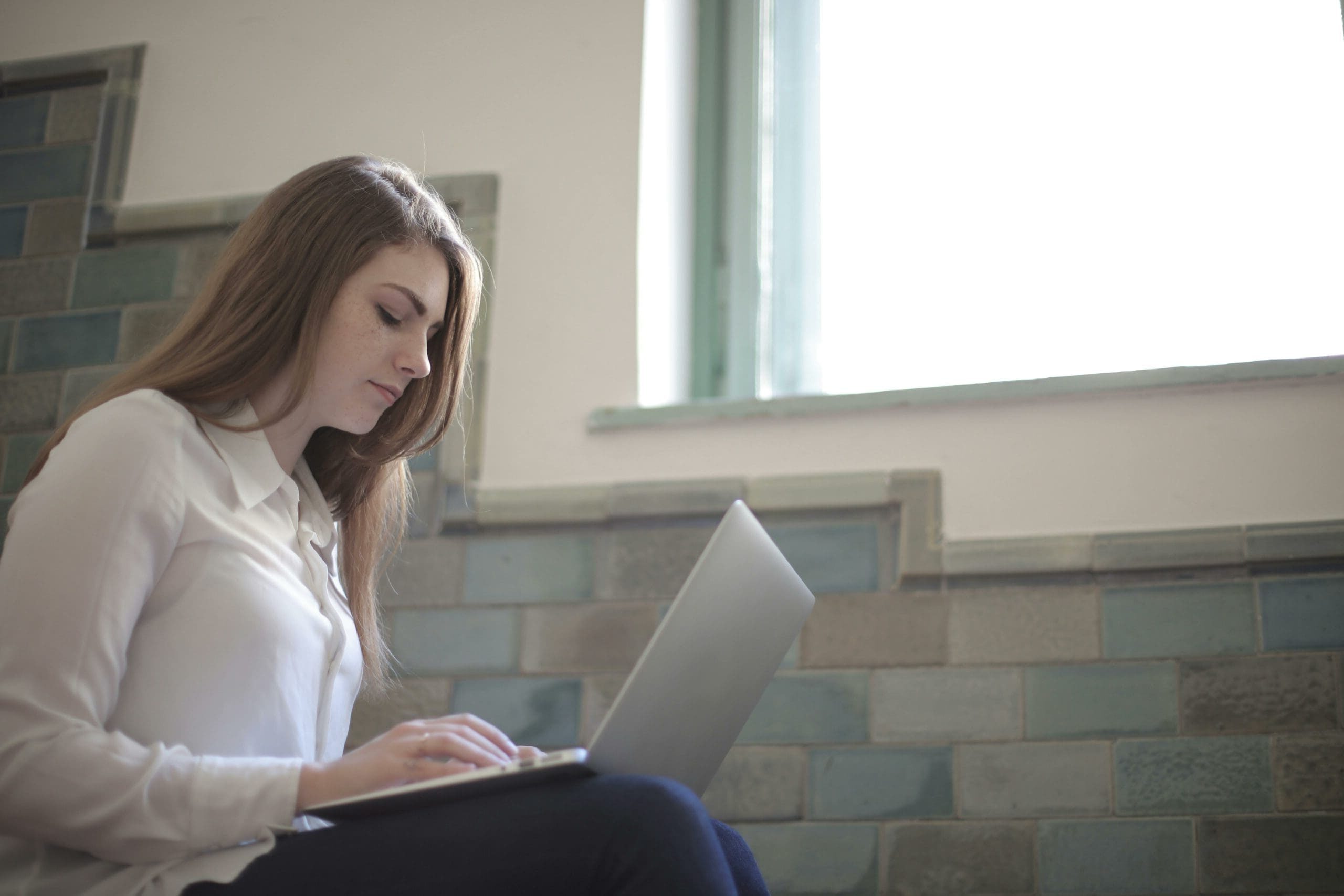 Woman in white shirt using laptop computer